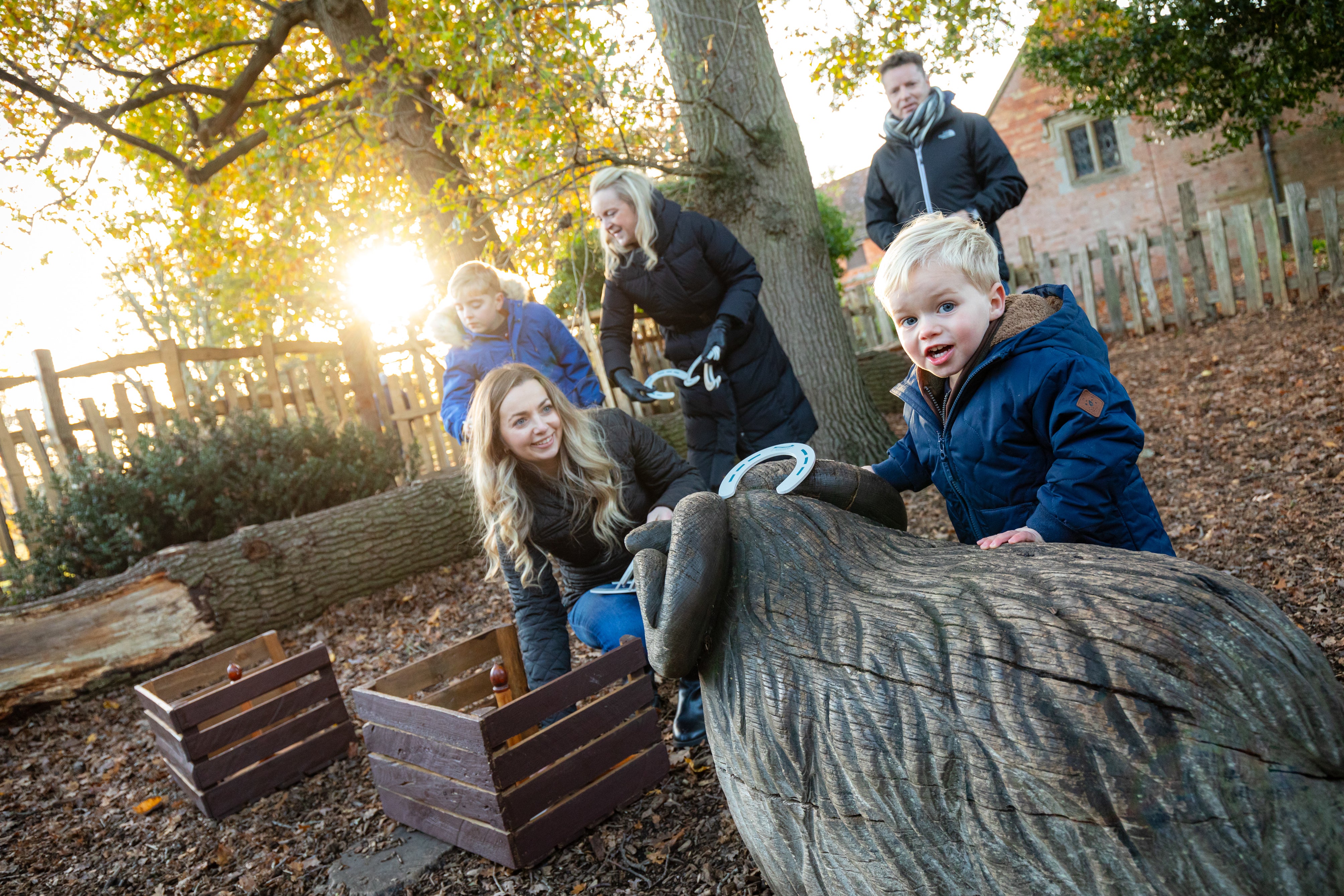 Multi-generational family playing with horseshoes on the trail in Charlecote's Spinney