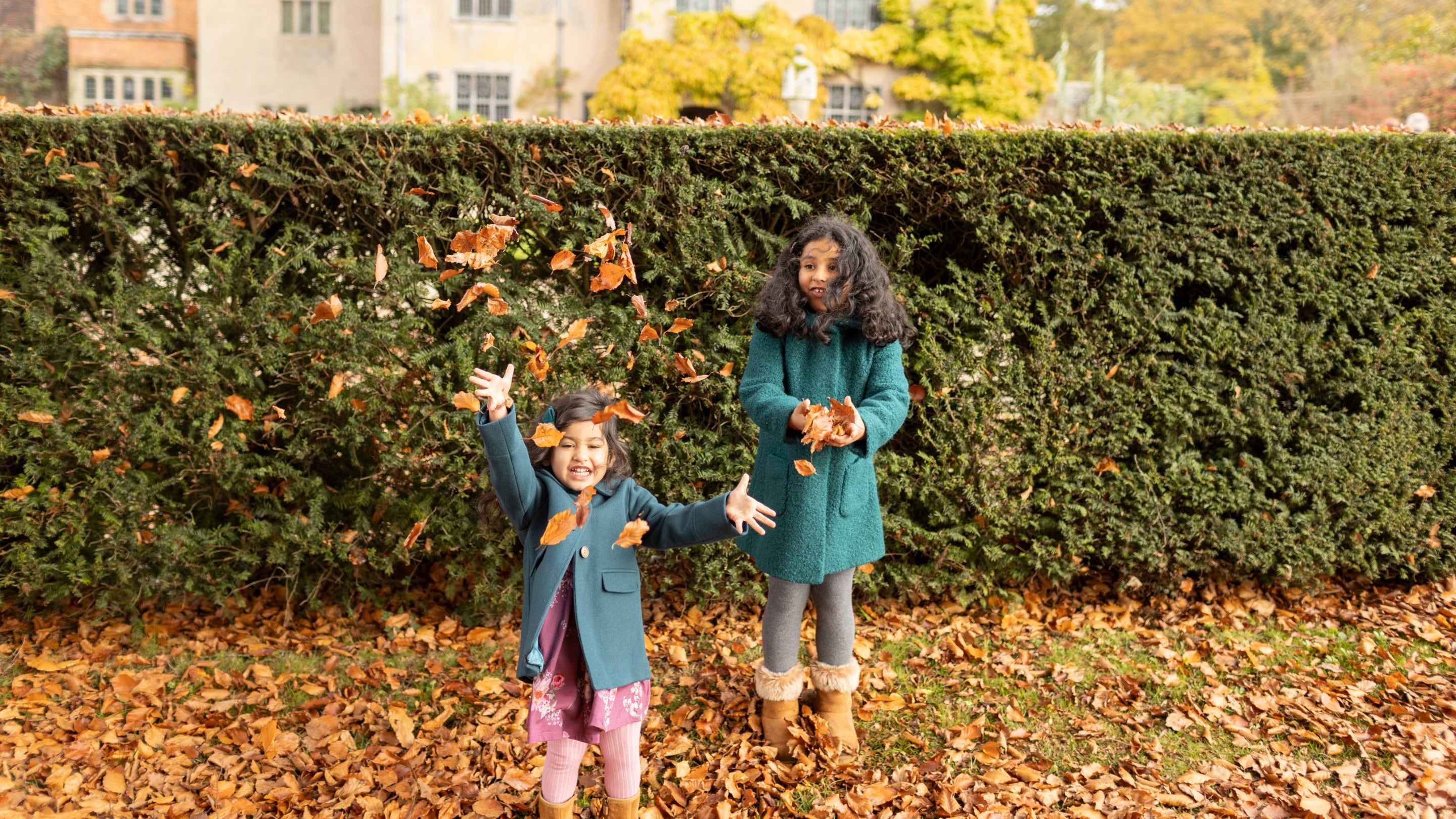 Children playing in autumn leaves at Packwood House, Warwickshire