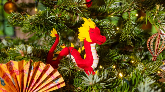 A tiny dragon hand-made from felt adorns a Christmas tree at Packwood House, Warwickshire