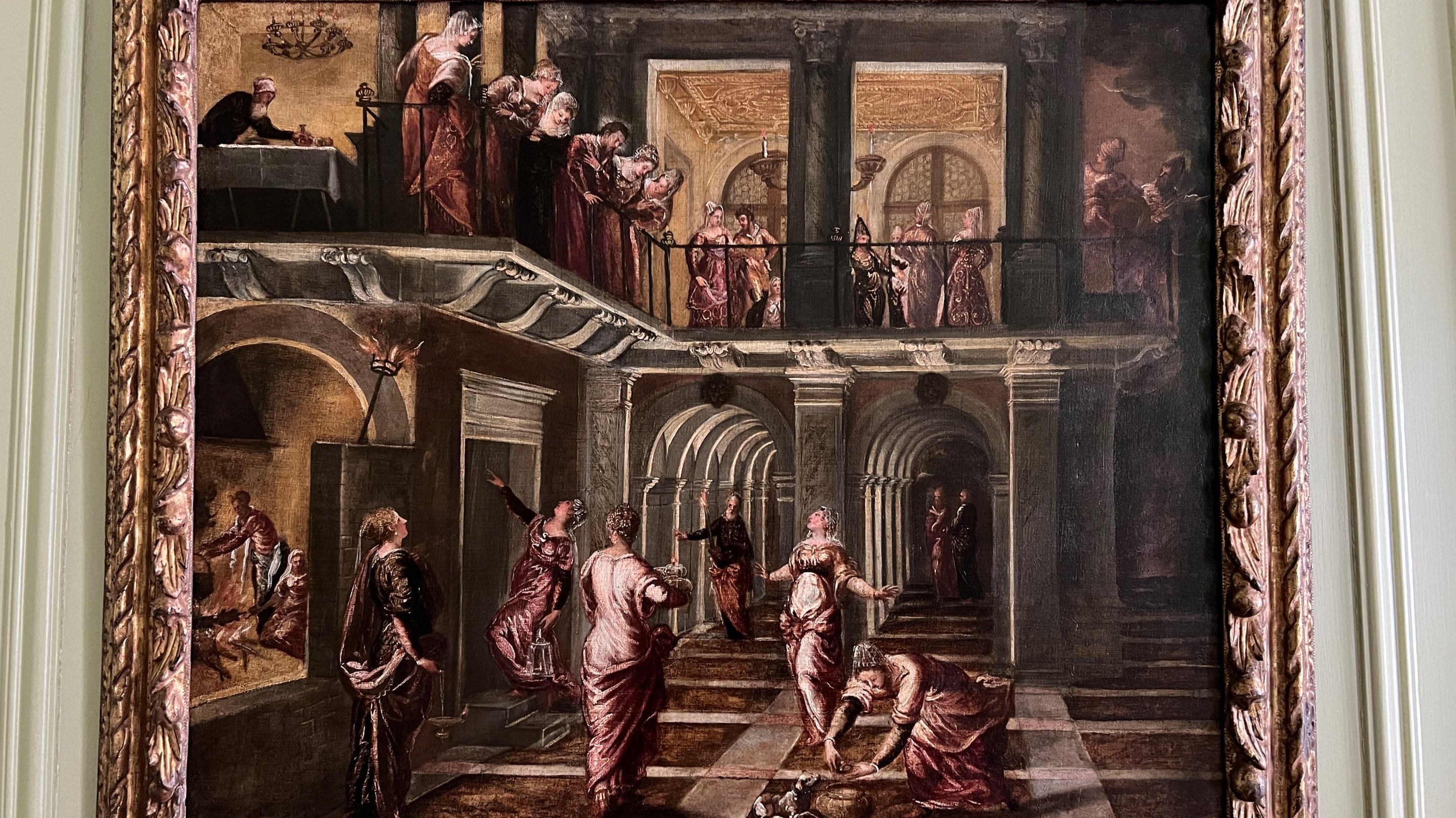 A close up of the painting the Wise and Foolish Virgins by Tintoretto on the wall at Upton House. The painting shows several figures, a balcony and the colours looking bright and refreshed.