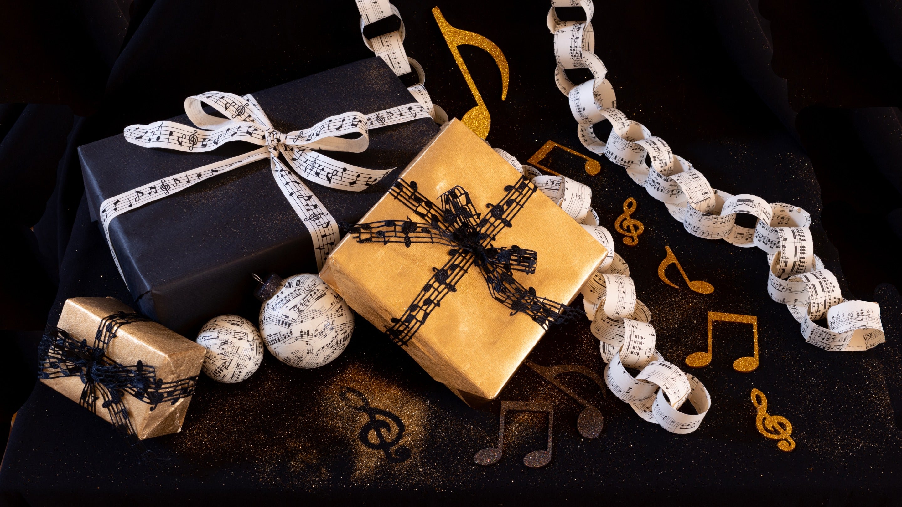 Presents wrapped in gold and black paper with musical note themed ties