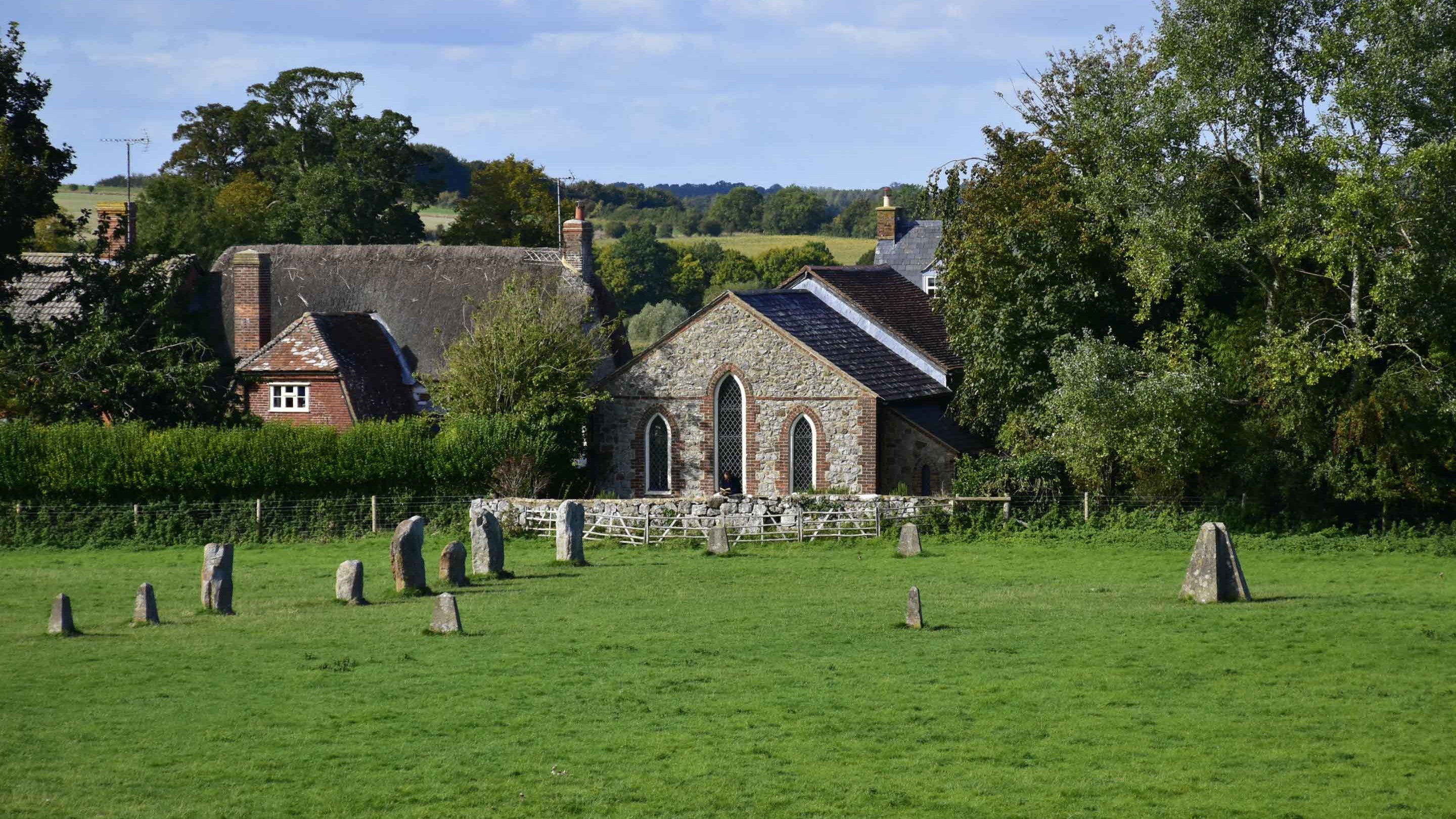 Inner stone circle and site of obelisk with chapel in background,  Avebury, Wiltshire