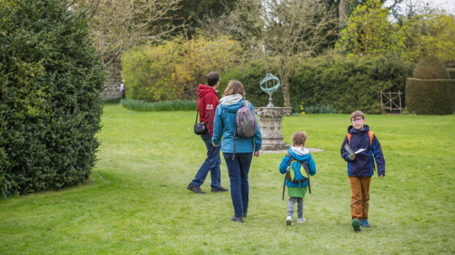 A family of four exploring the Avebury Manor Garden as part of an Easter Egg trail.