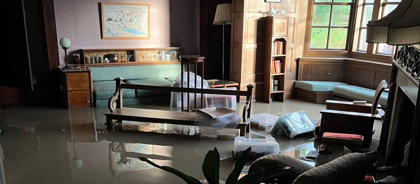 An image showing furniture submerged in floodwater in the Keiller Parlour inside Avebury Manor.