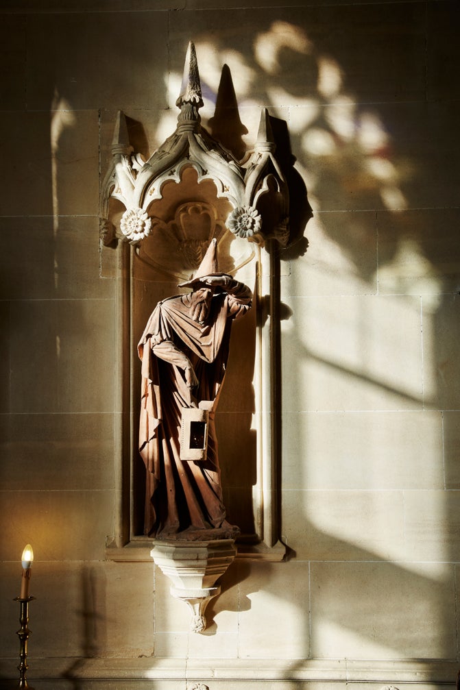 An image of one of the terracotta statues displayed on the wall in Lacock's Great Hall. It is believed to portray Diogenes with his lamp, he has one hand to his eyes and the sun is shining on him.