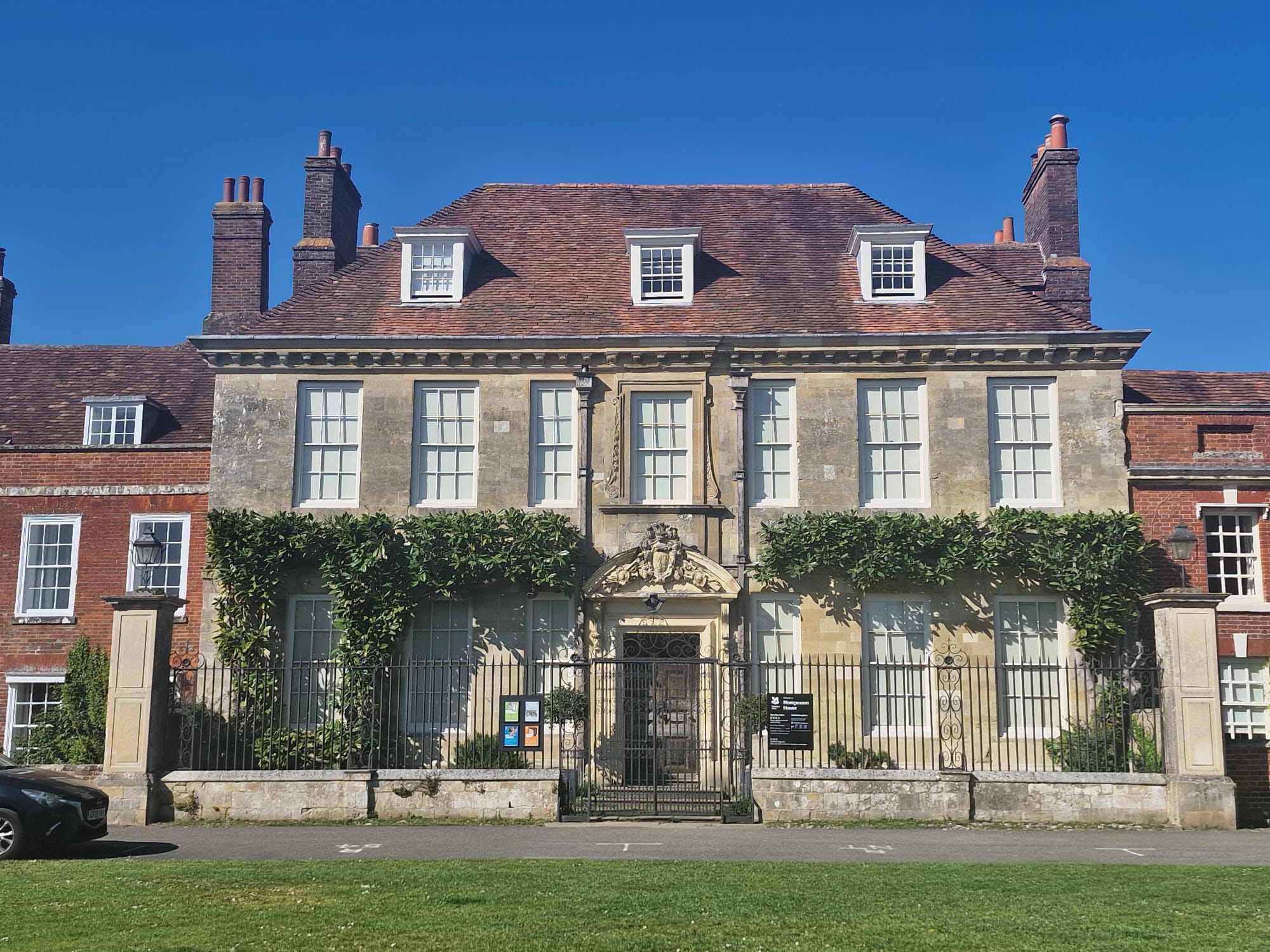 An eighteenth-century townhouse on a sunny day. Its window frames are freshly painted with white paint