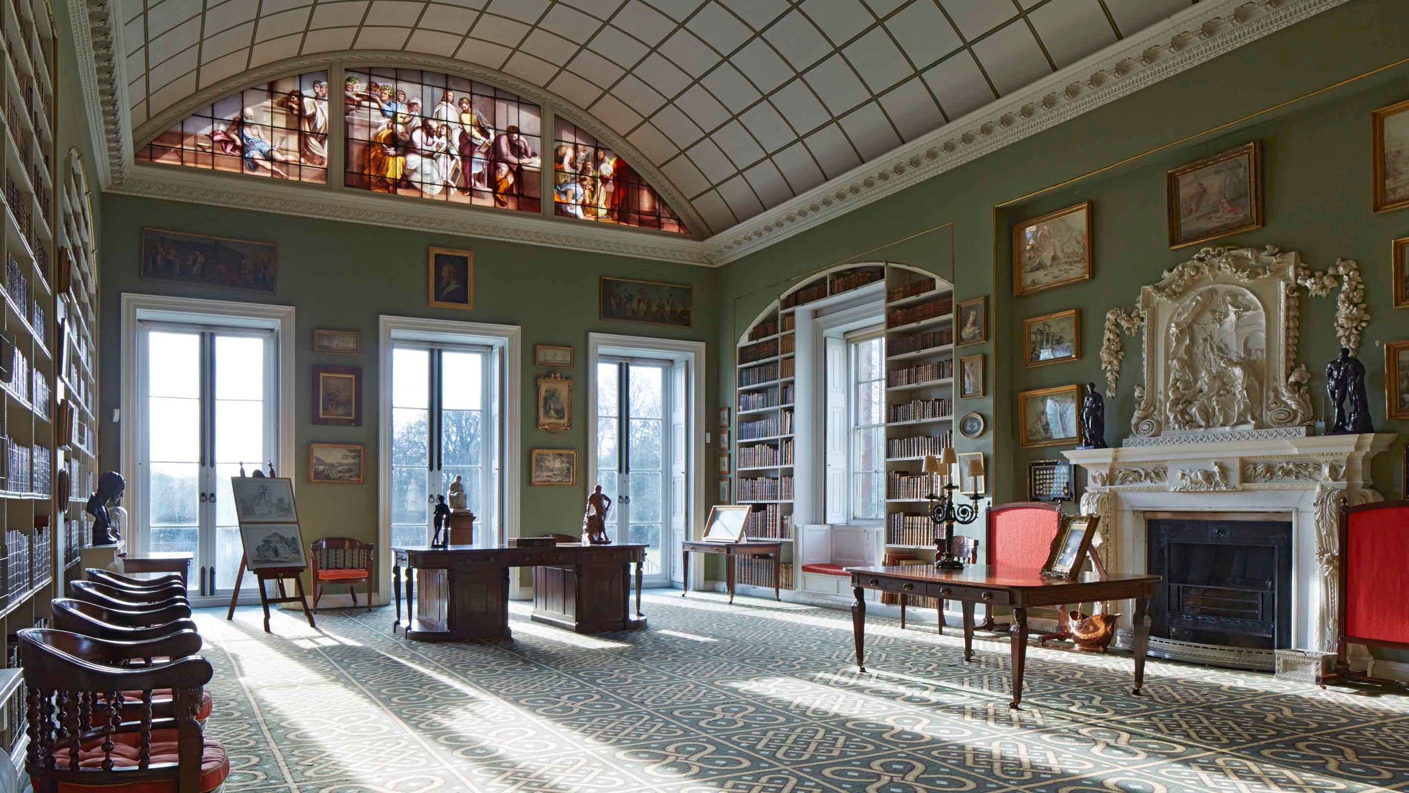 Inside the library at Stourhead with light streaming through big windows and an arched ceiling