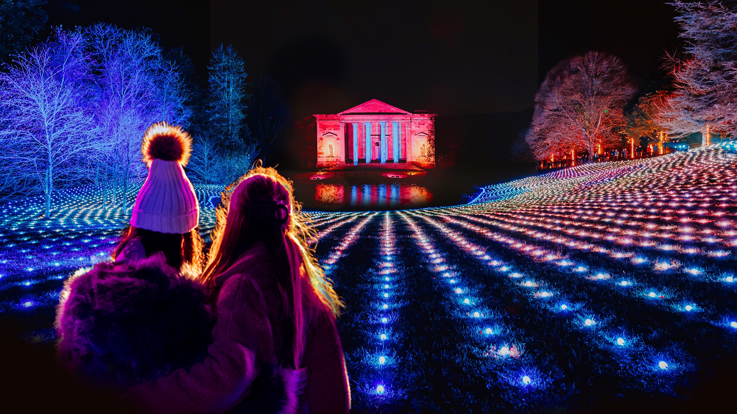 A women and girl looking across the illuminated garden towards the Pantheon