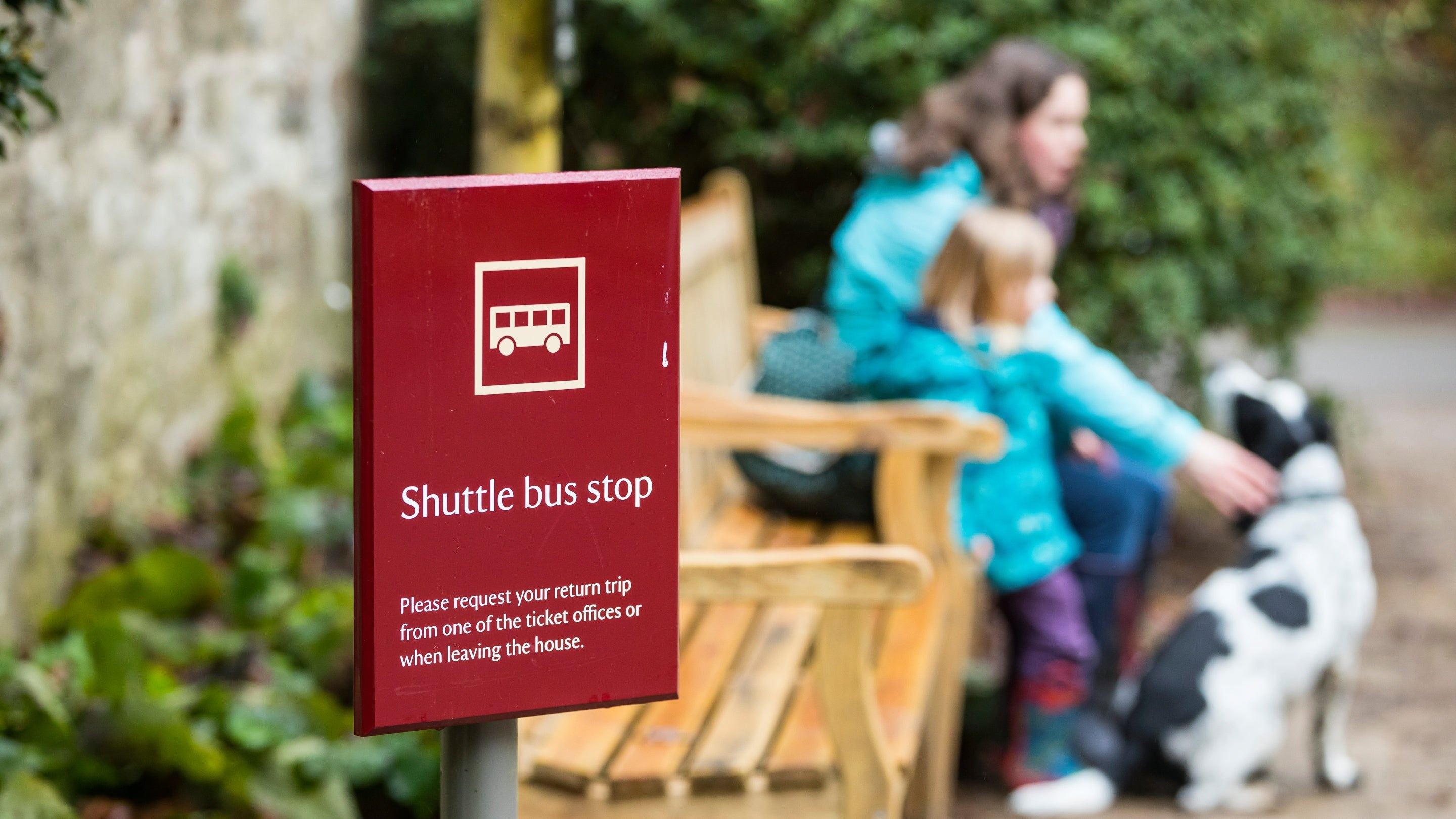 Visitors waiting by the shuttle bus stop at Stourhead, Wiltshire