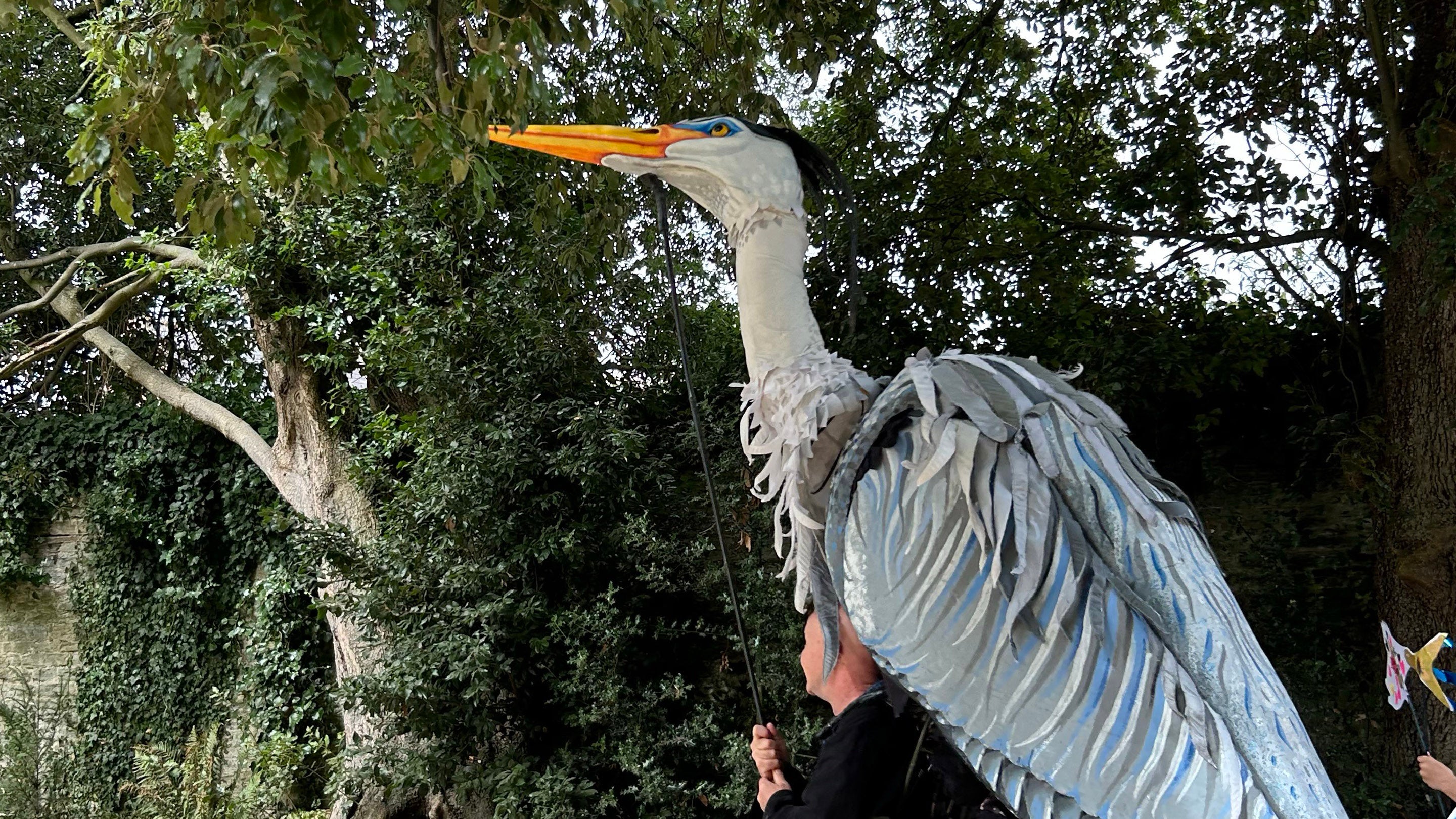 A giant Heron puppet worn by a puppeteer