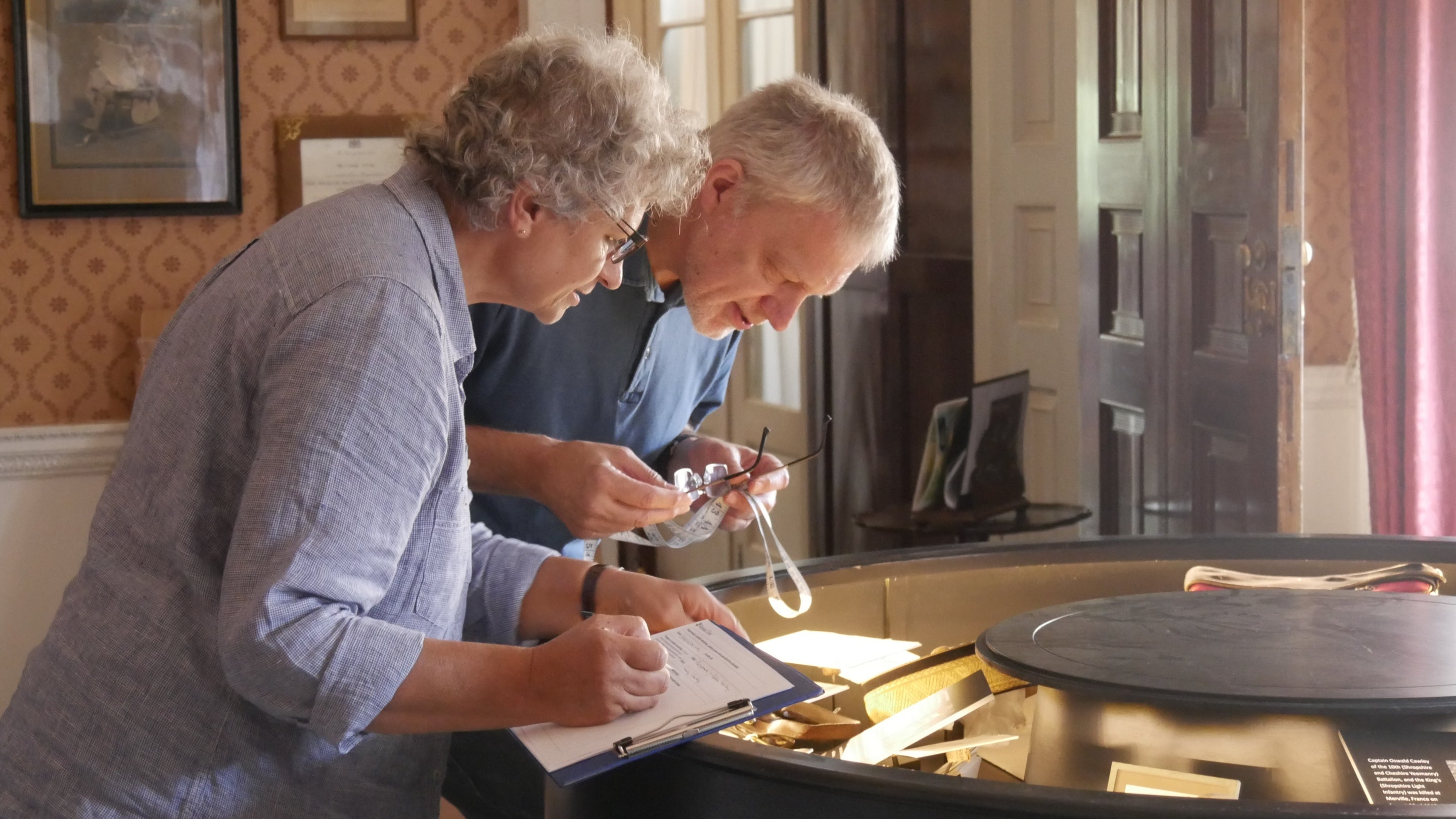 Two volunteers are inspecting some of the items on display at Berrington Hall, Herefordshire.
