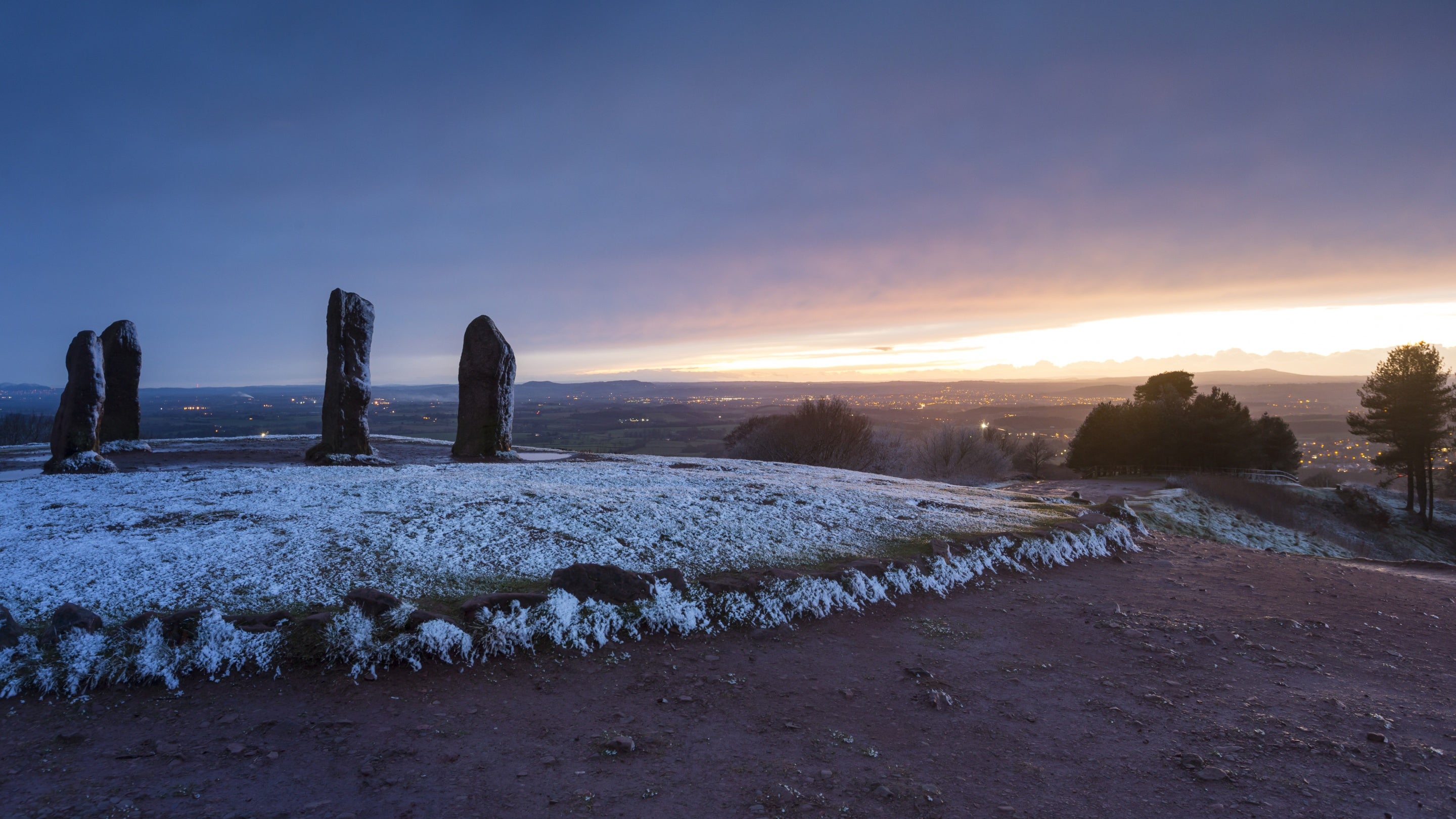 A winter sunrise over the Four Stones, tall rectangular standing stones at Clent Hills, Worcestershire.