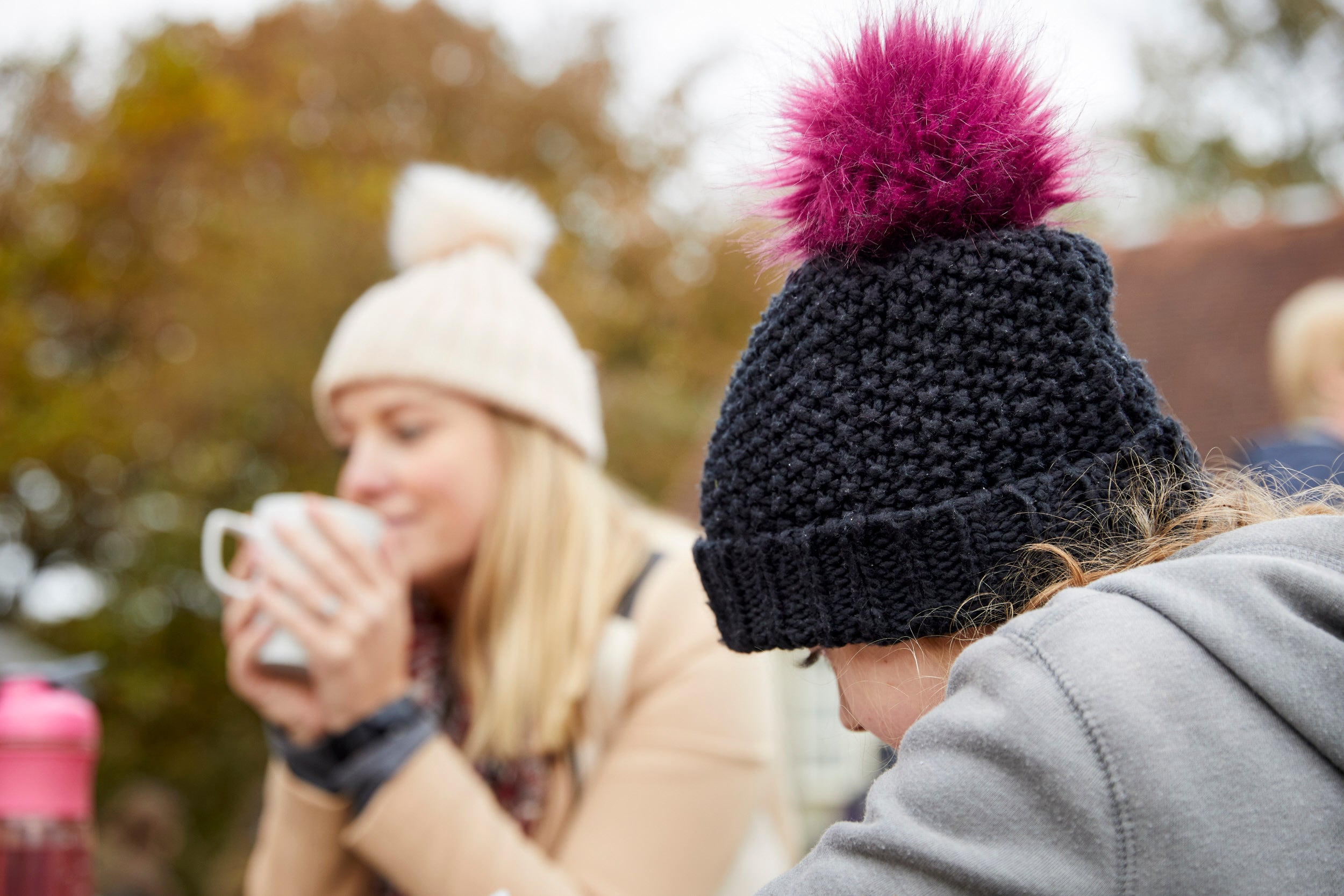Two visitors sipping hot drinks outside a cafe