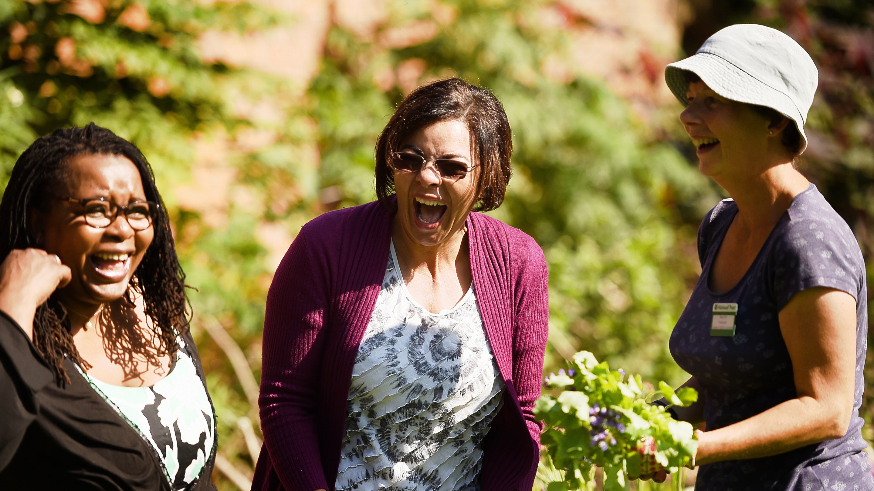 Visitors chatting to the gardener in the garden at Hanbury Hall and Gardens, Worcestershire