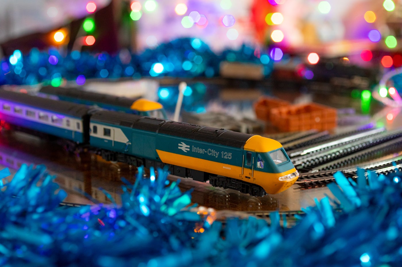A retro train set surrounded by tinsel and fairy lights