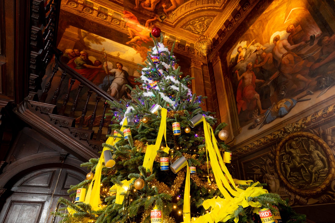 A big Christmas tree in the Great Hall at Hanbury Hall decorated with a trifle theme