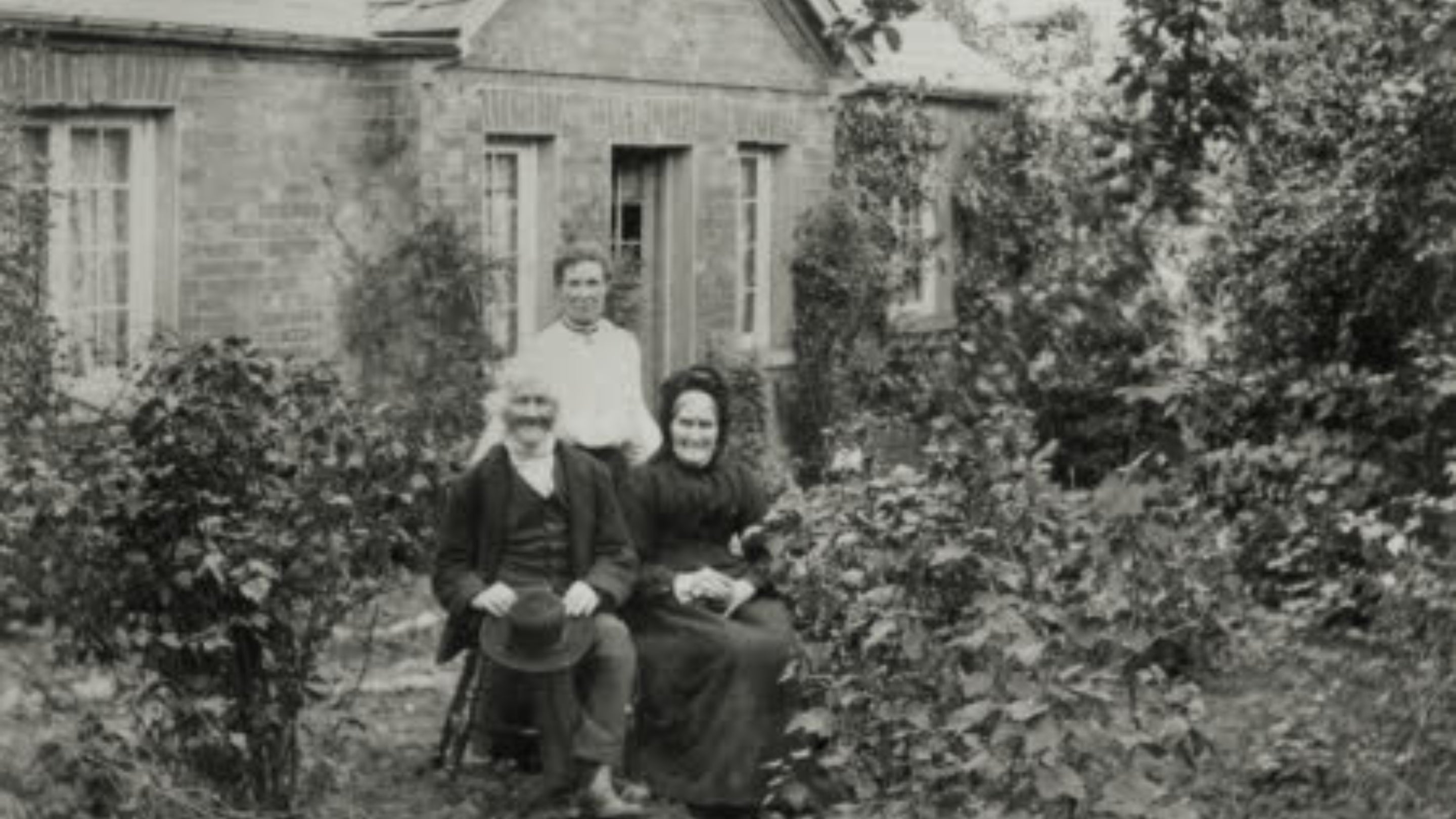 Mr and Mrs Baker and their daughter seated outside their cottage at Rosedene, Worcestershire