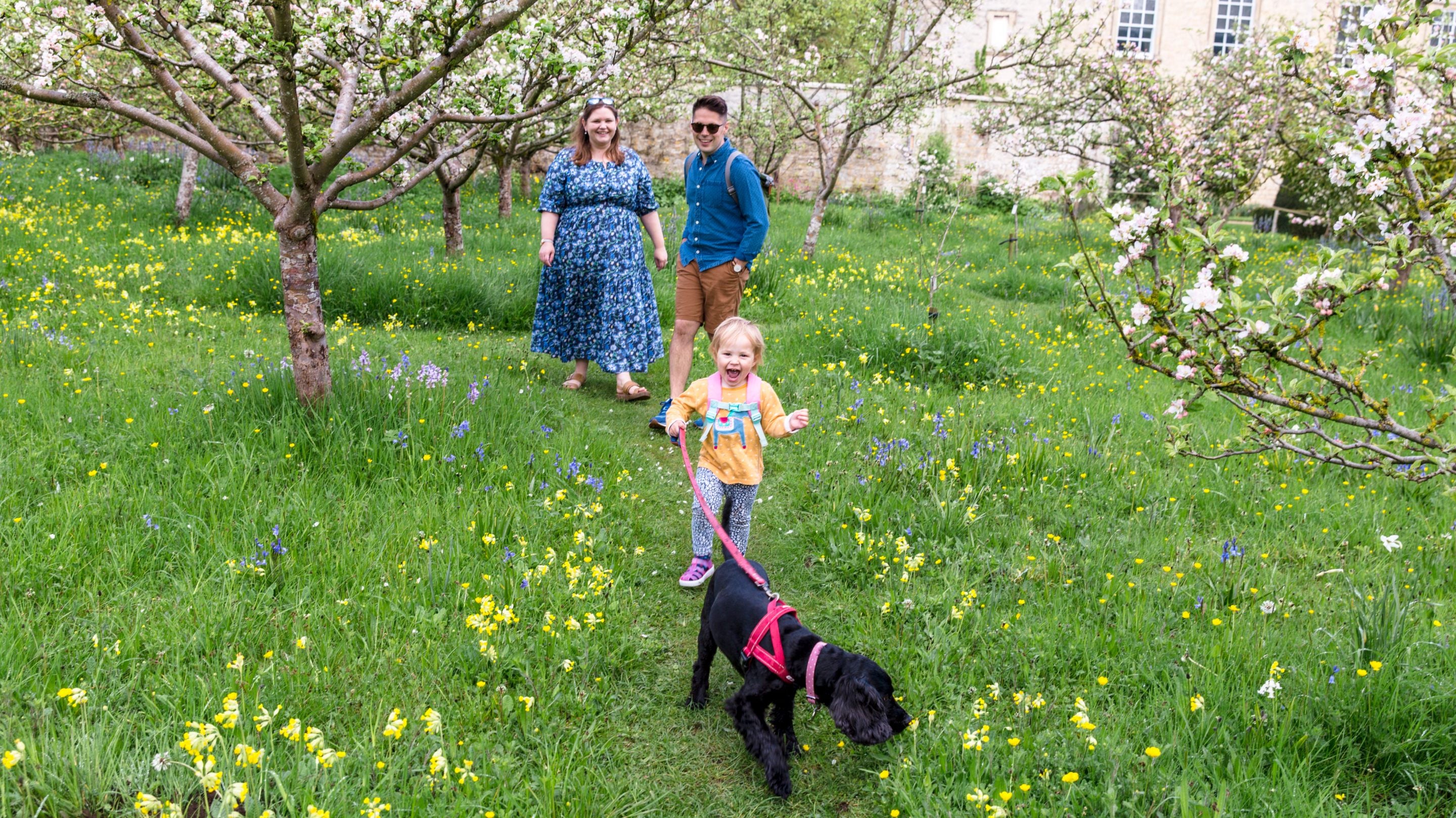 A family with their dog walking in the garden at Nunnington Hall, North Yorkshire