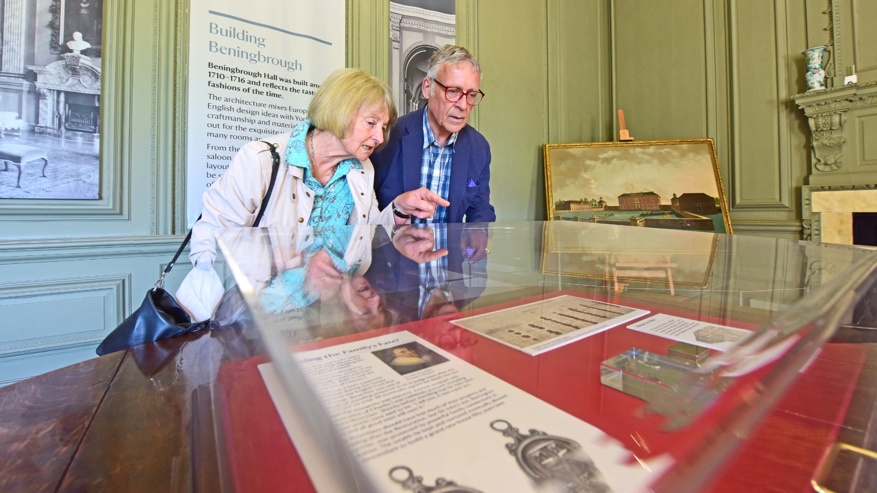 Two people looking at parts of the collection in a glass case