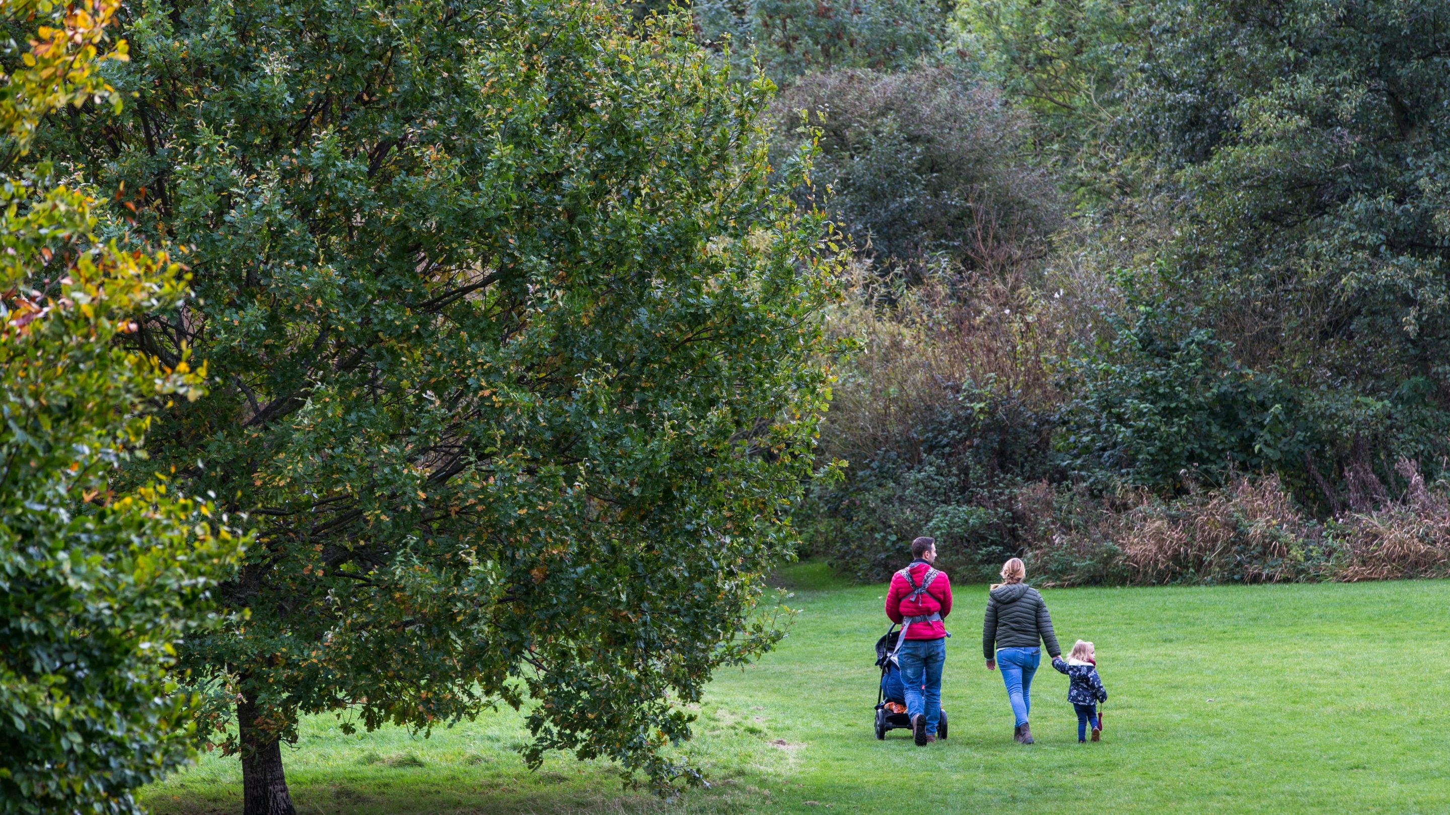 Visitors exploring the lower fields in autumn at East Riddlesden Hall