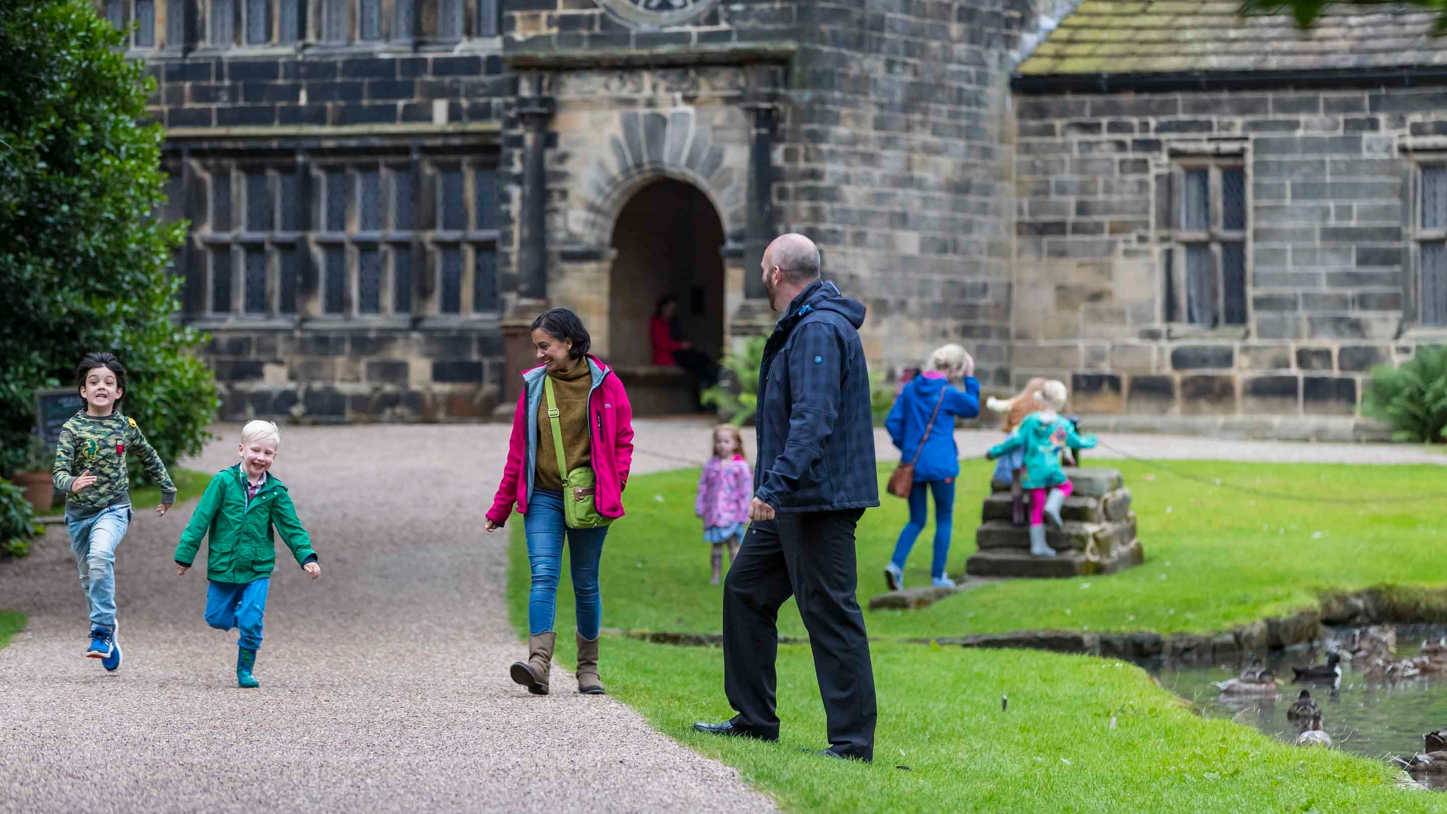 Children racing along a path in the garden at East Riddlesden Hall, West Yorkshire