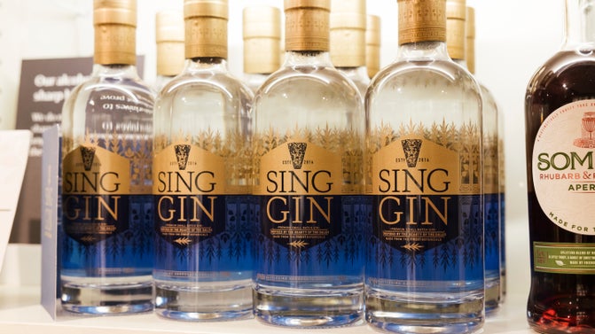 Bottles of sing gin on a white shelf in the shop at East Riddlesden Hall