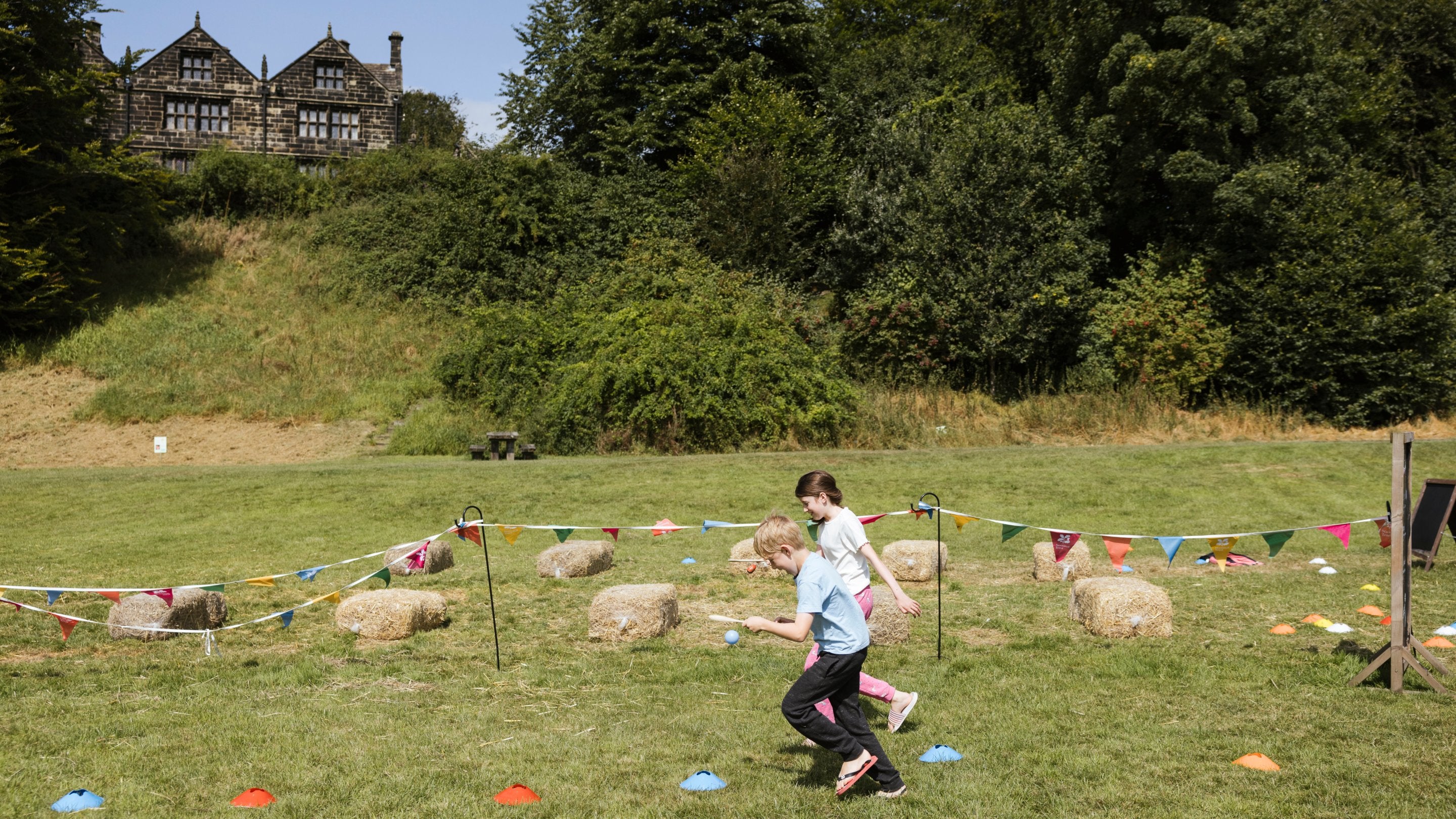 Children playing sports games on the lower fields at East Riddlesden Hall, Yorkshire