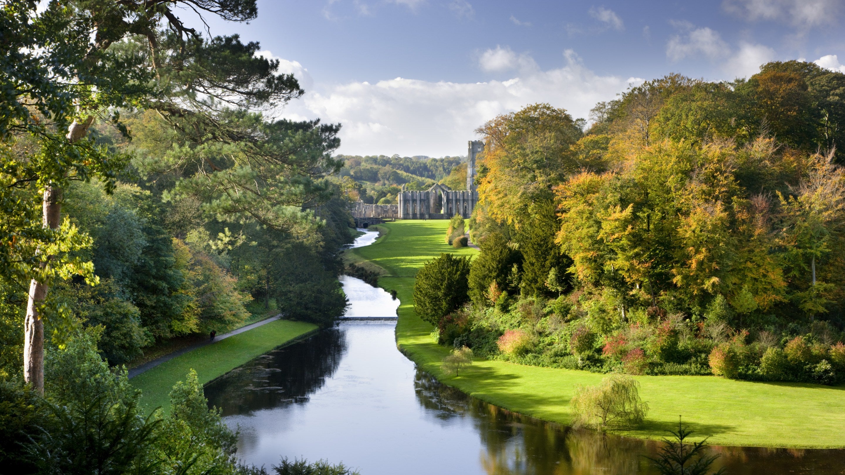Looking over the Half Moon Pond and weir of Studley Royal Water Garden from the Surprise View towards Fountains Abbey, North Yorkshire.