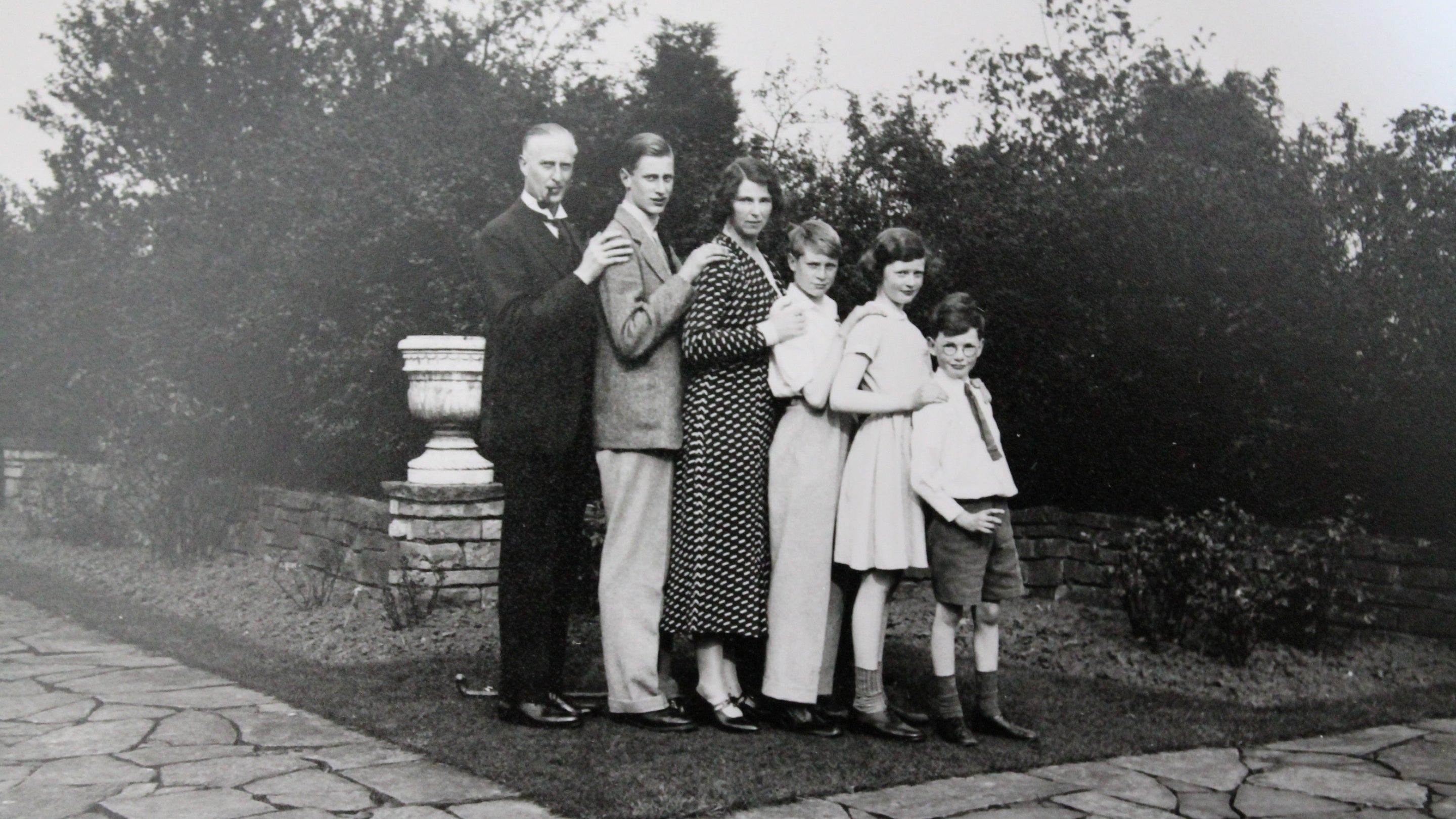 Black and white image of a family stood side by side in height order