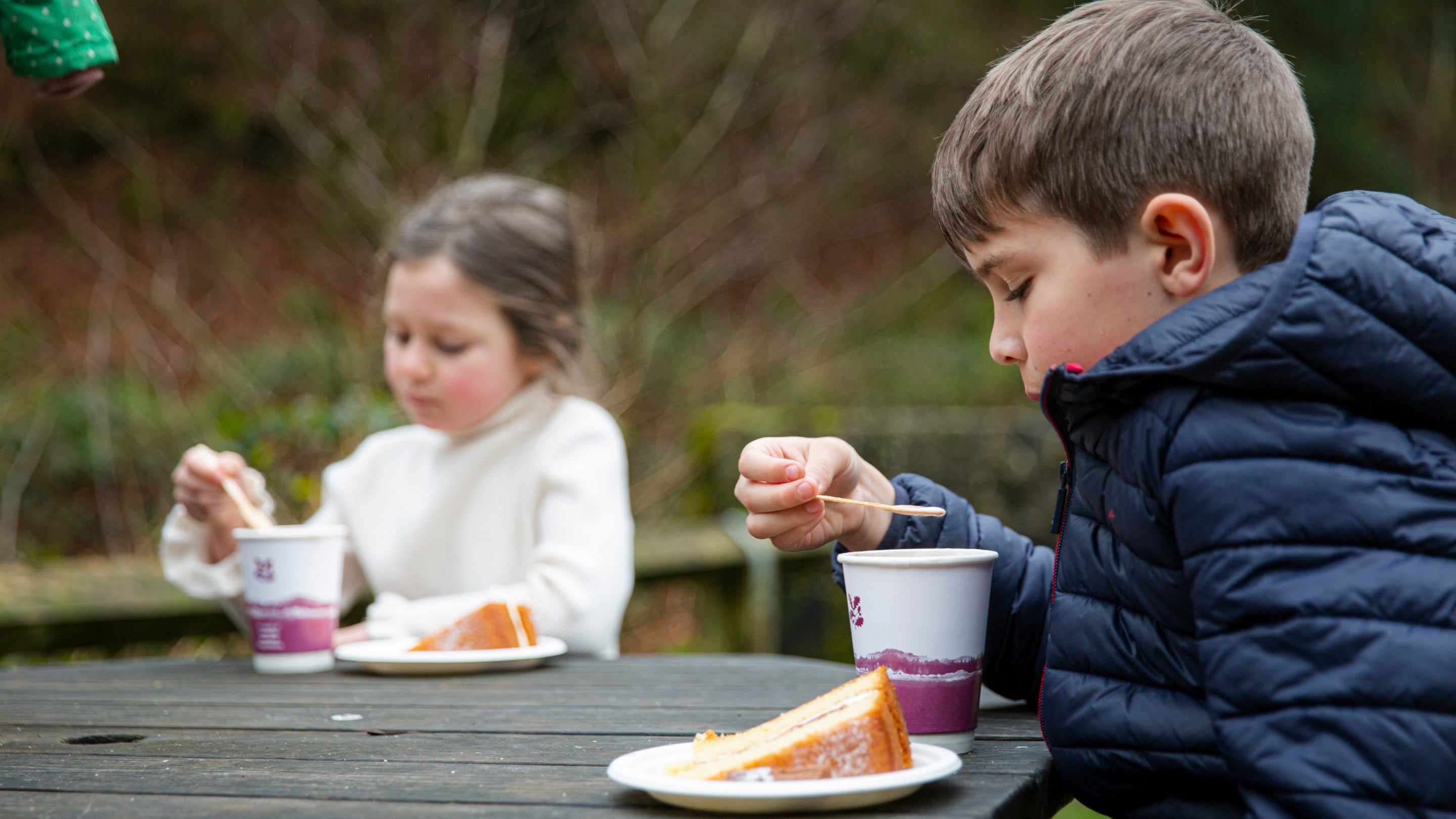 Family enjoying cakes outside Gibson Mill