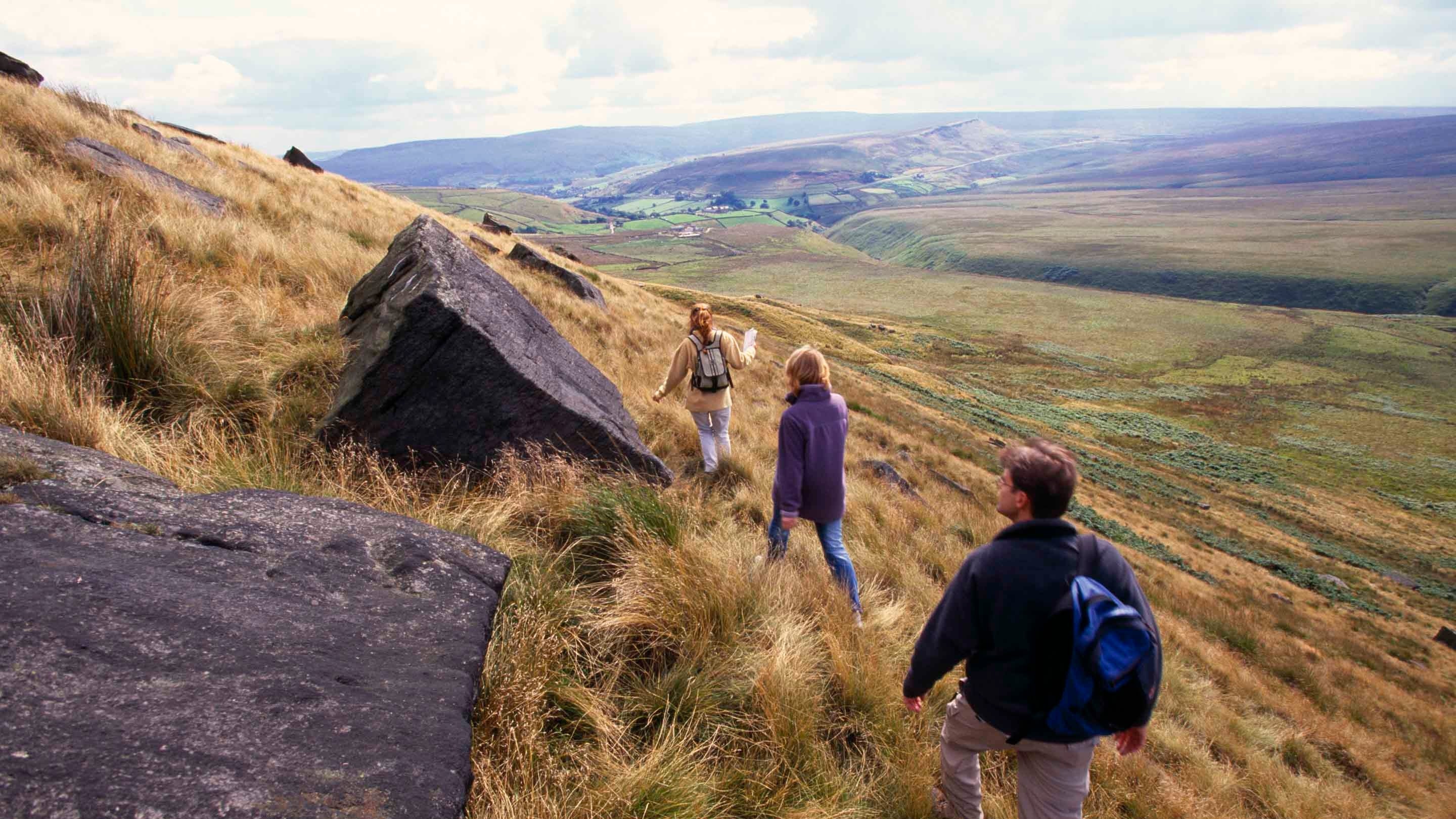 People climbing on one of the steep sided valleys of Buckstones Moss in the north of the Marsden Moor Estate, West Yorkshire