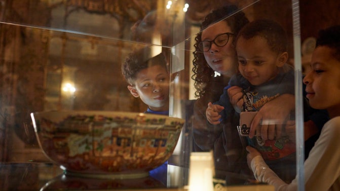 A family looking through a glass case at the Hongs Bowl on display at Nostell