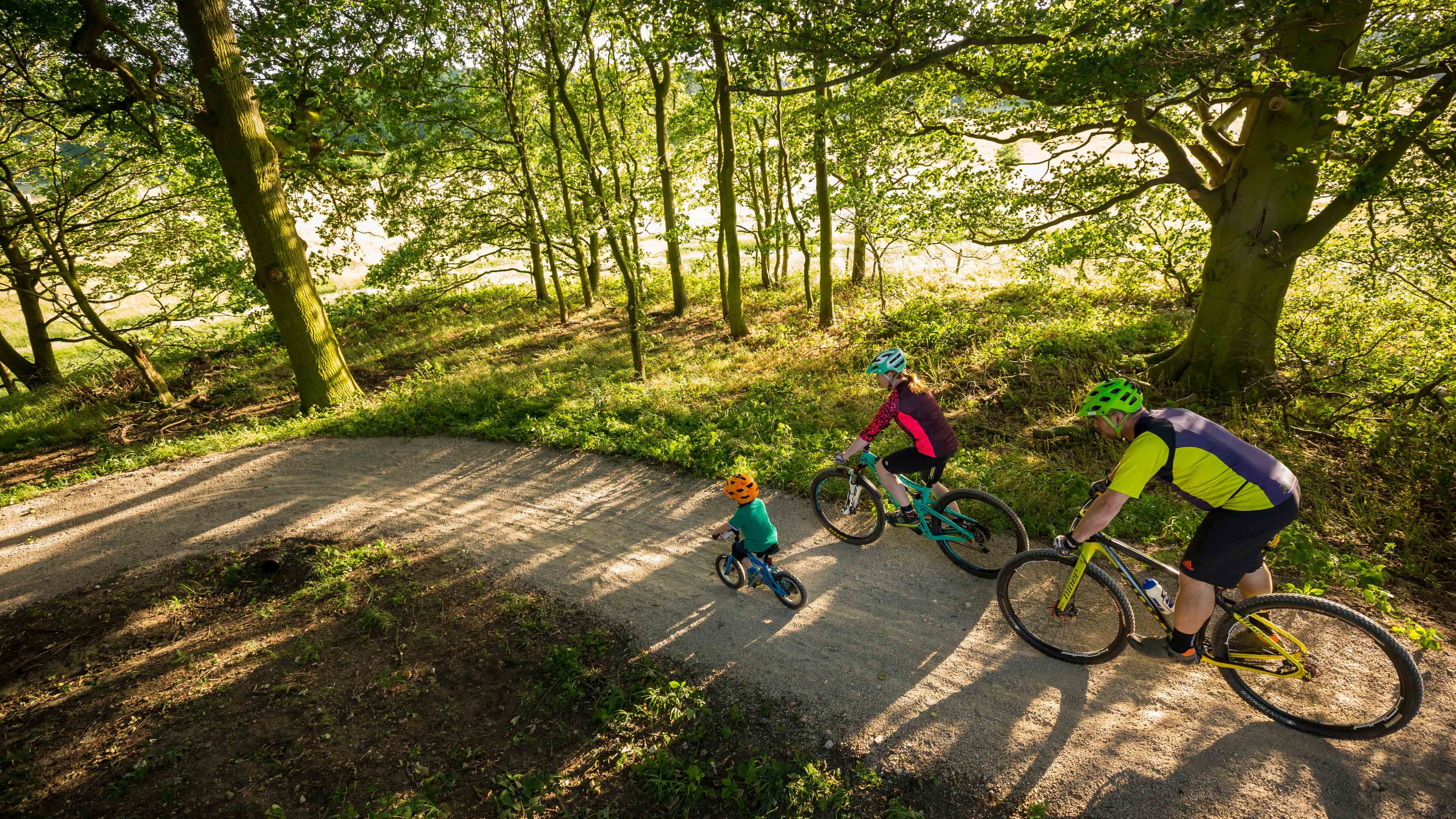 Family visitors cycling on one of Nostell's bike trails in Summer