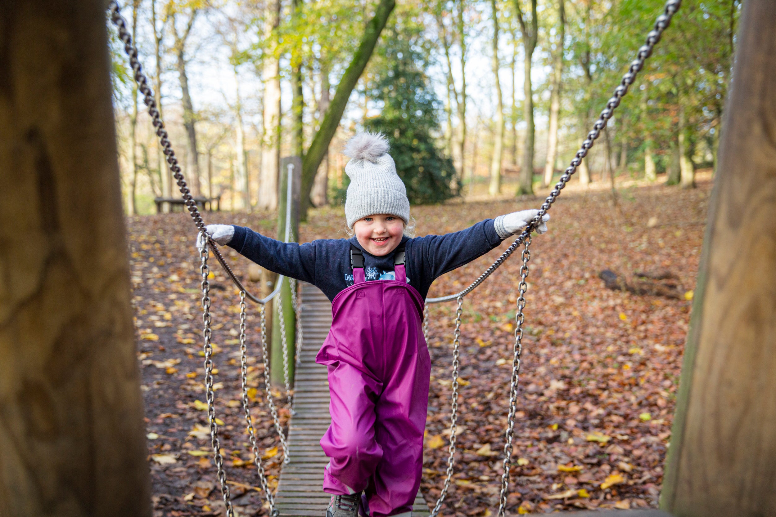 Child playing on a wooden bridge in the playground at Nostell