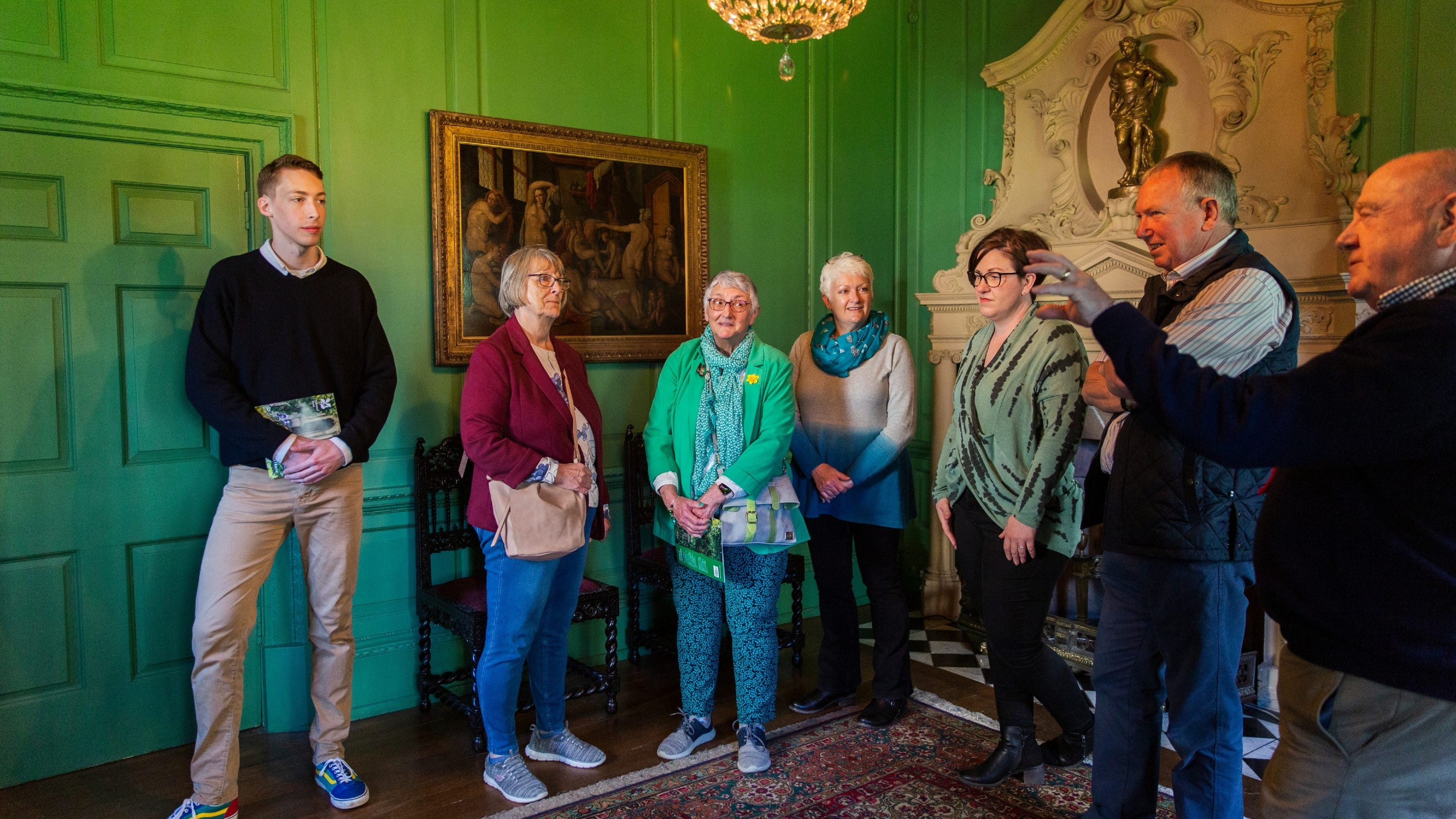 A group of people standing listening to a tour guide