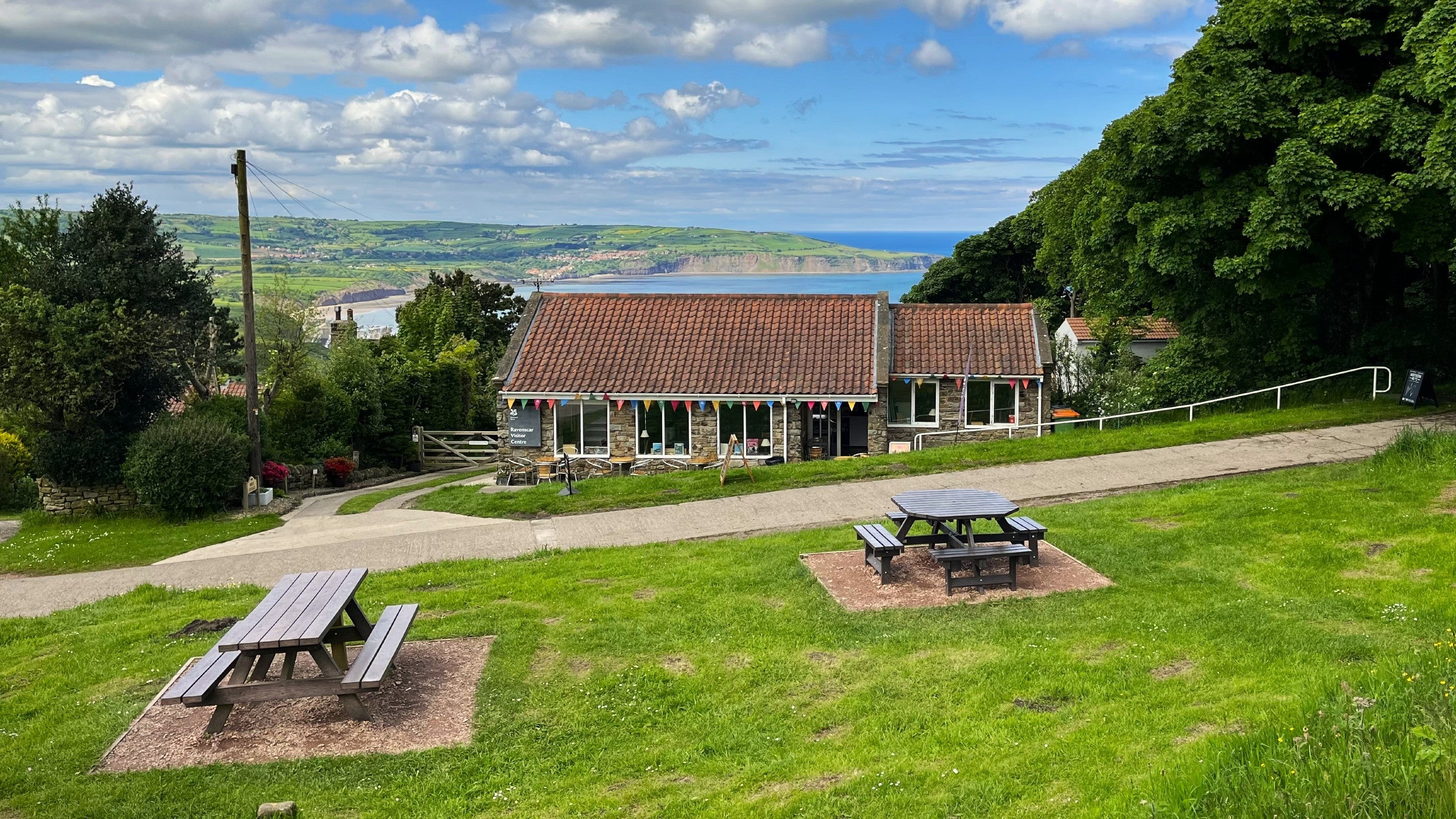 Ravenscar Visitor Centre in late spring with Robin Hood's Bay in background